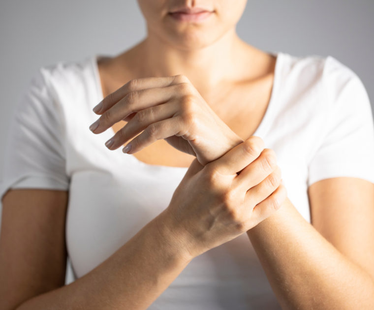 Photo de femme se tenant la main illustrant les douleurs articulaires du poignet